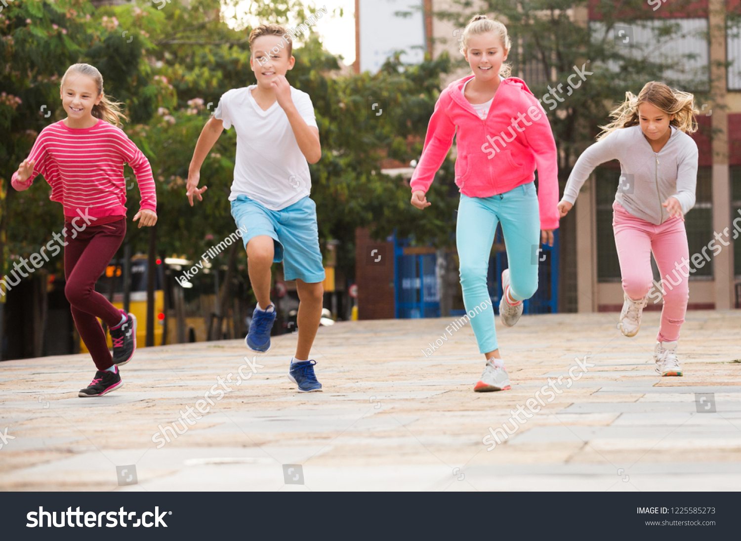 Company of active kids are jogning together in the park. #1225585273
