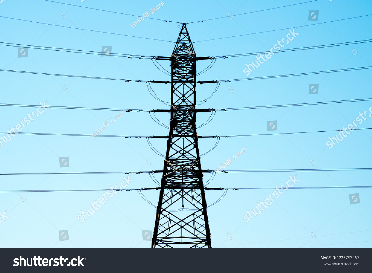 High voltage transmission line and transmission tower under blue sky #1225753267