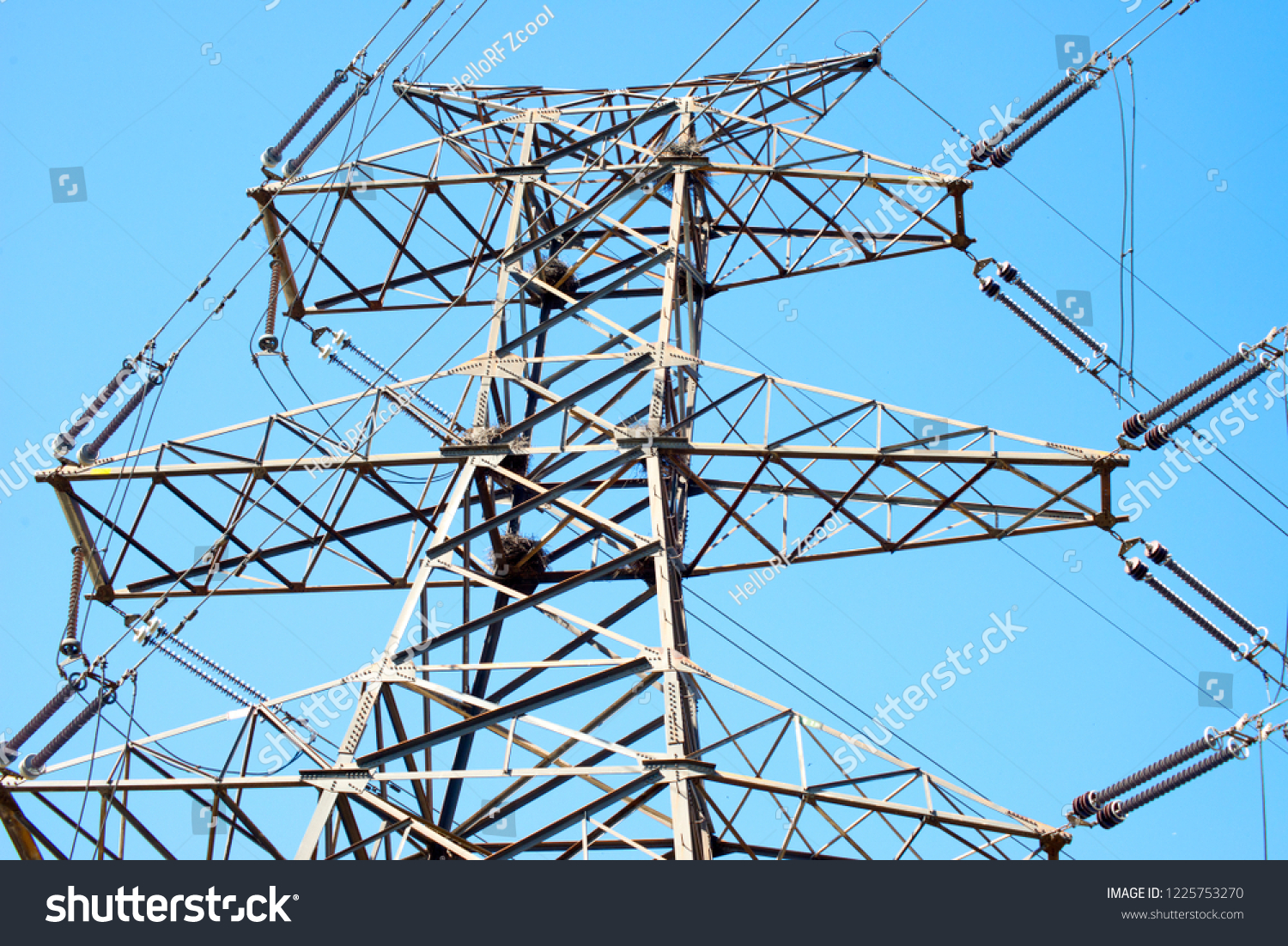 High voltage transmission line and transmission tower under blue sky #1225753270