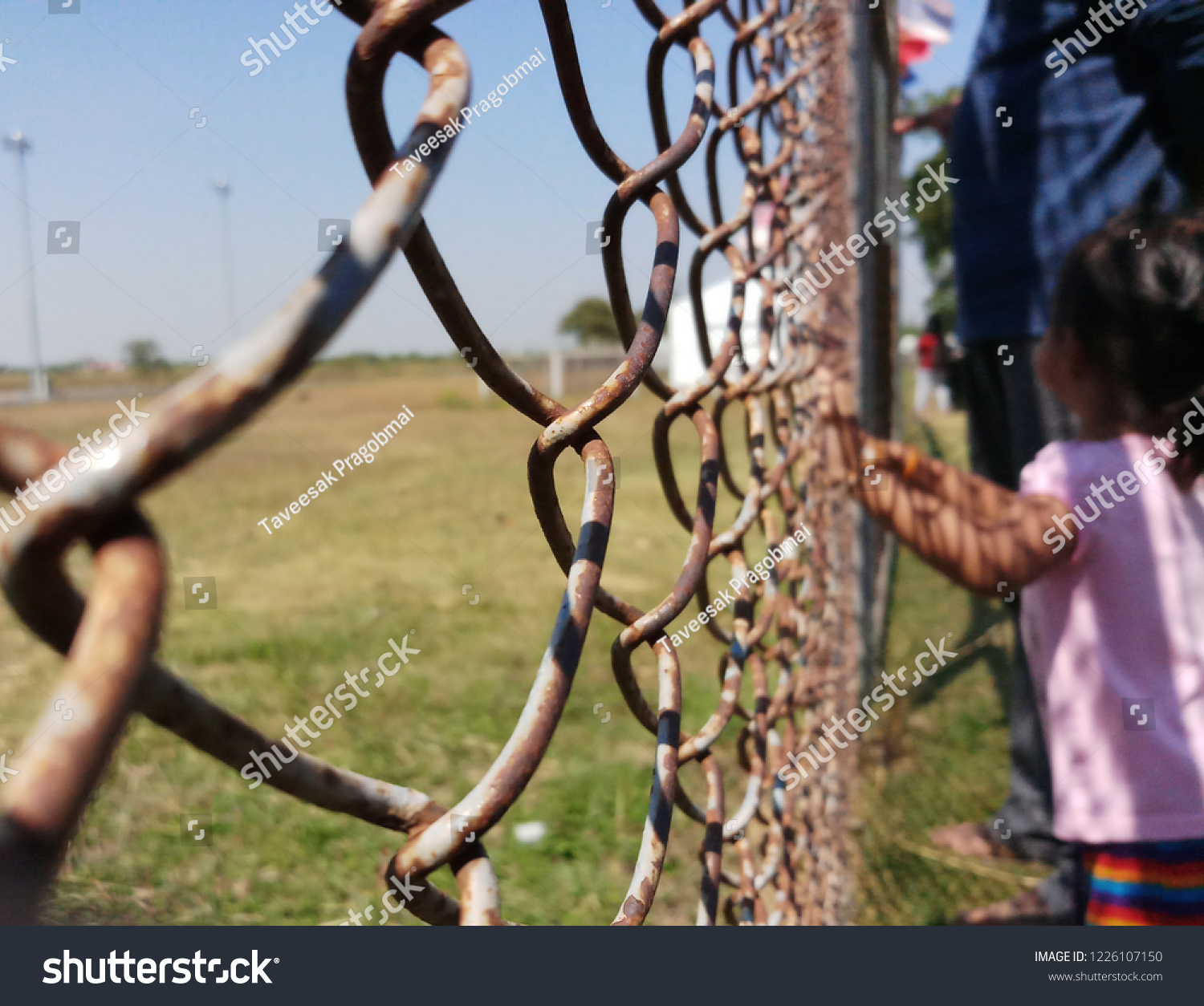 Girl hands holding wire fence #1226107150