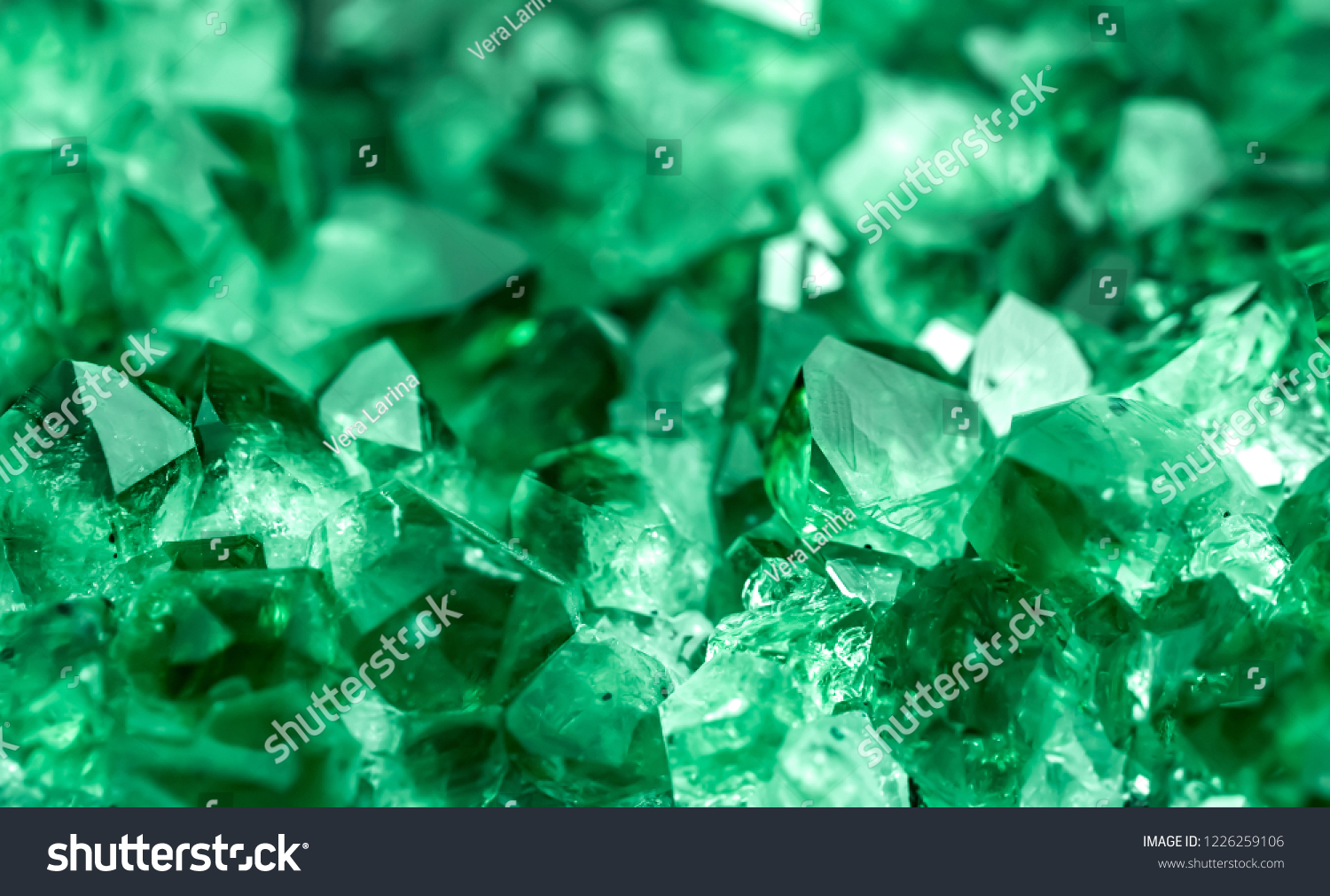 Green crystal mineral stone. Gems. Mineral crystals in the natural environment. Texture of precious and semiprecious stones. Seamless background with copy space colored shiny surface of precious stone #1226259106