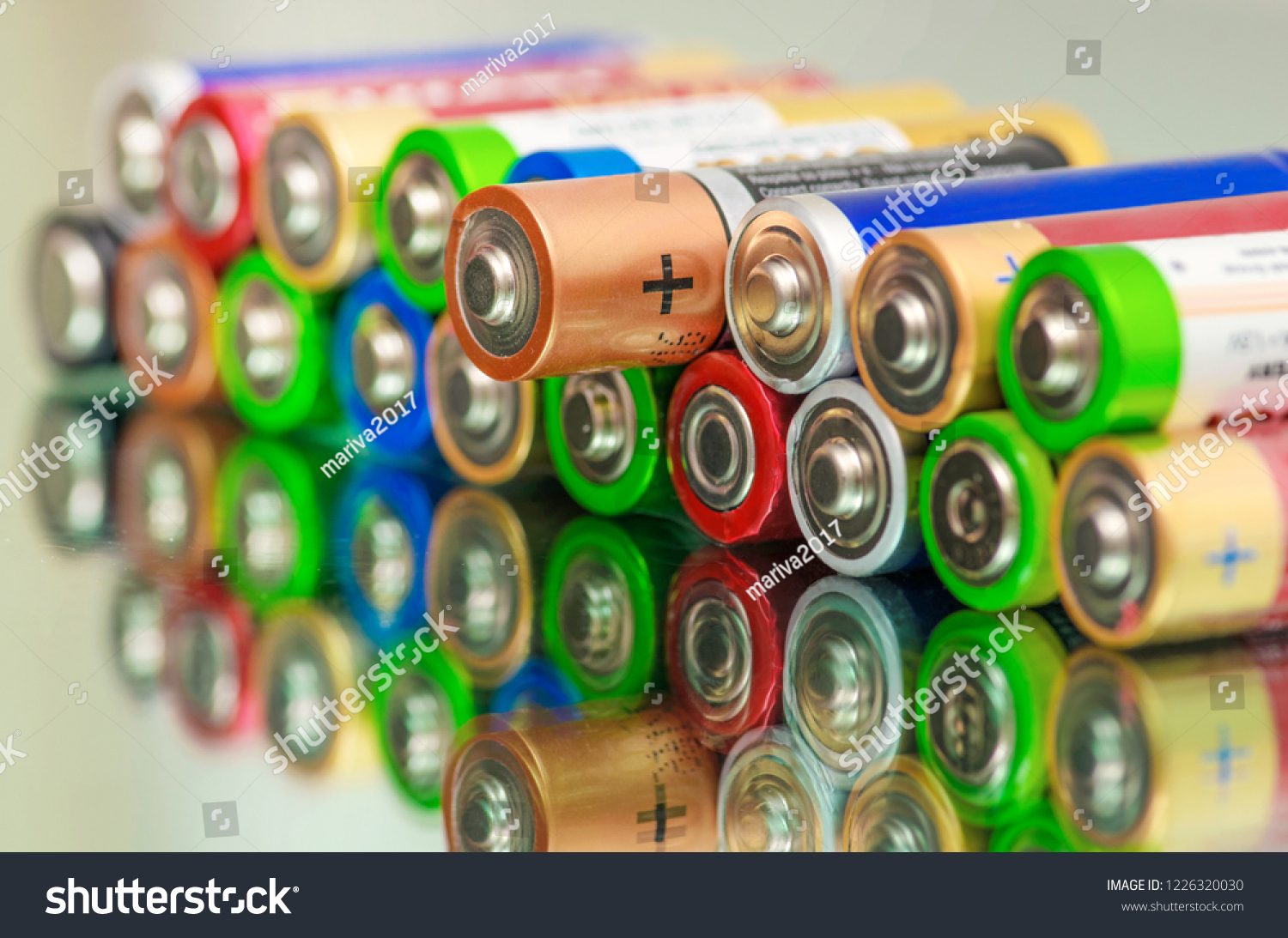 Closeup of pile of used alkaline batteries. Close up colorful rows of selection of AA batteries energy abstract background of colorful batteries. Alkaline battery aa size. Several batteries in rows. #1226320030