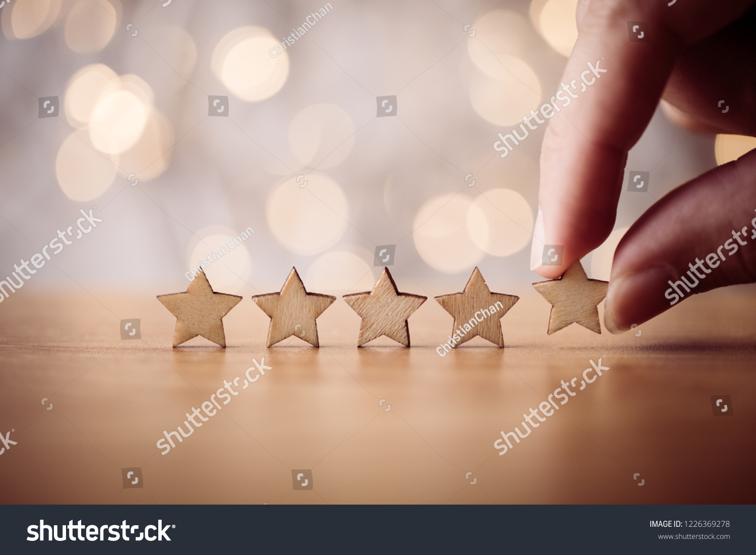 Hand putting wooden five star shape on table. The best excellent business services rating customer experience concept. #1226369278