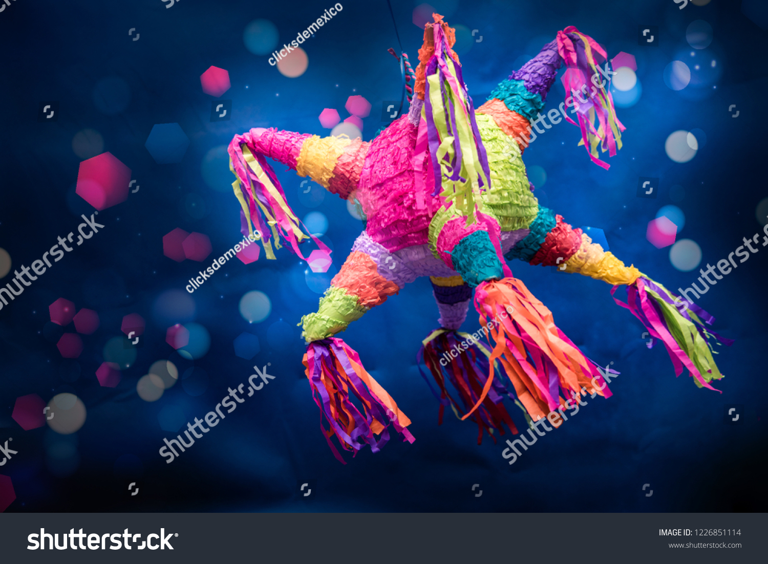 mexican piñata party hanging on blue and green background with multi-colored glitters celebrating birthday, christmas, party, party songs, figure in the shape of star and donkey, family fun #1226851114