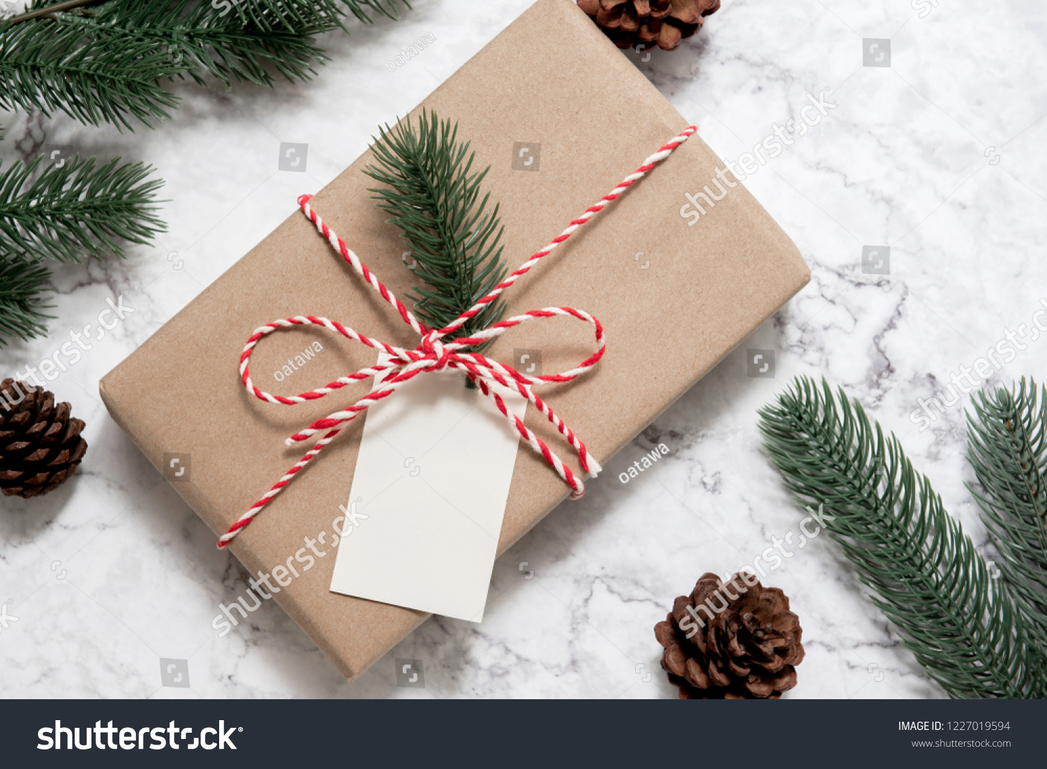 Christmas gift box with note card and tree branch decor on marble background. Flat lay, Top view with copy space #1227019594