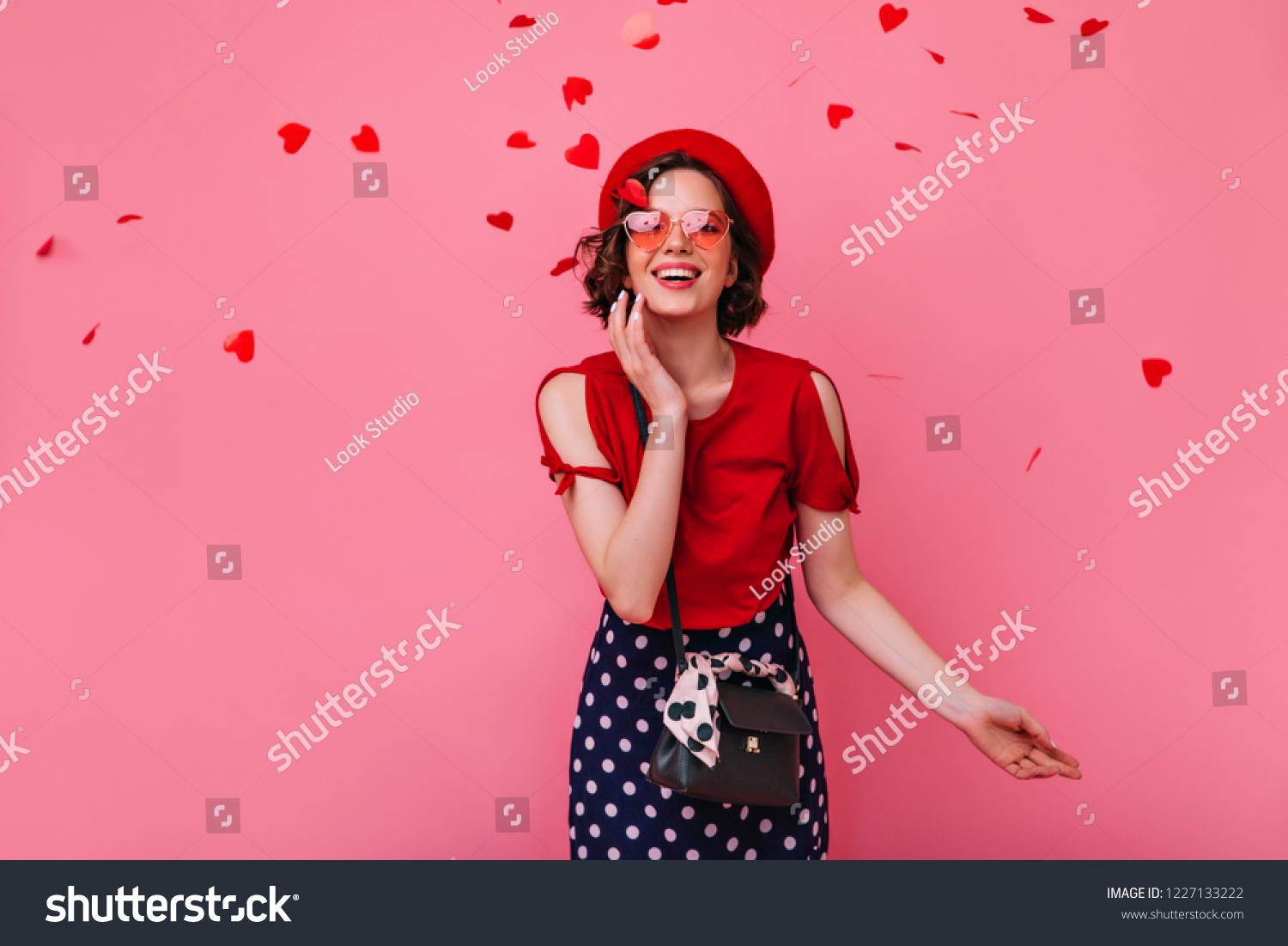 Romantic white woman with brown hair expressing happiness in valentine's day. Enchanting stylish girl in funny glasses posing on rosy background with confetti. #1227133222