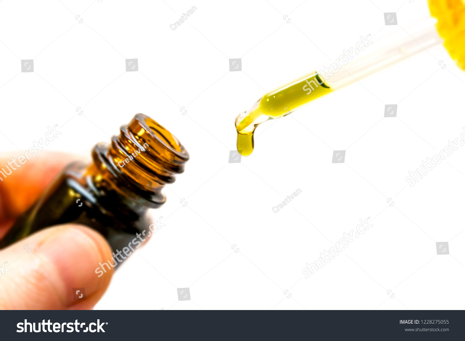 Hand holding bottle of Cannabis oil in pipette isolated on white #1228275055