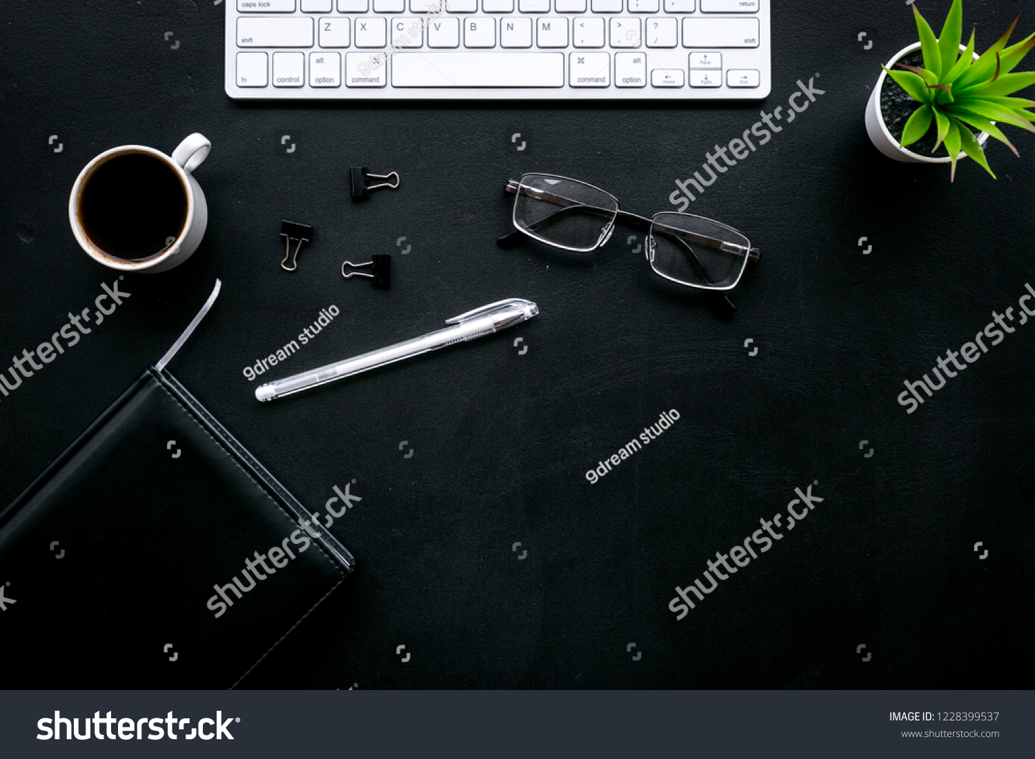 Office desk of chief, director or top manager. Computer keyboard, expensive black notebook, glasses, coffee on black background top view copy space #1228399537