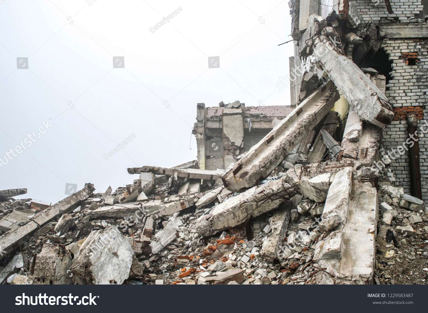 A huge pile of gray concrete debris from piles and stones of the destroyed building. The impact of the destruction. The impact of the destruction. Background. #1229583487