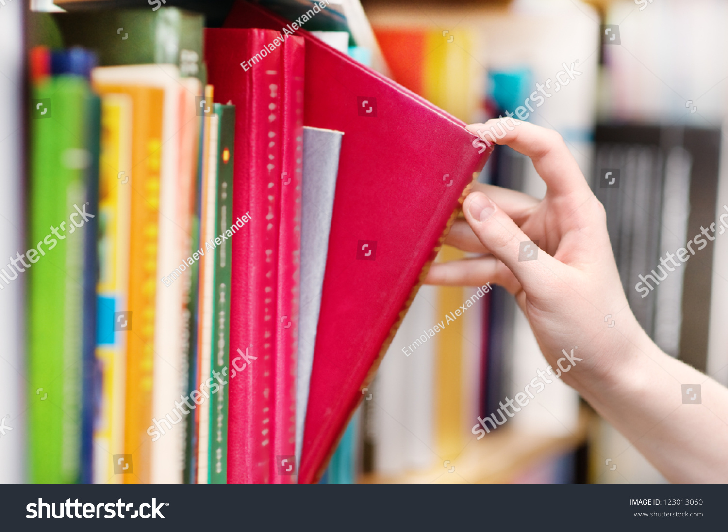 closeup  hand selecting book from a bookshelf #123013060