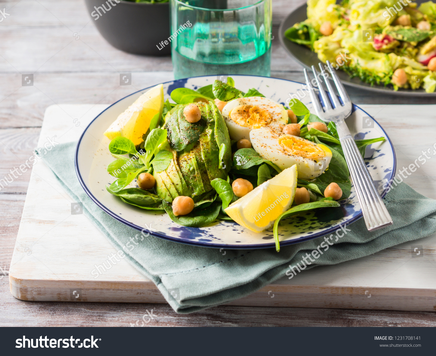 Avocado spinach salad with chickpeas and hard boiled eggs served on a dish. Fats and proteins #1231708141