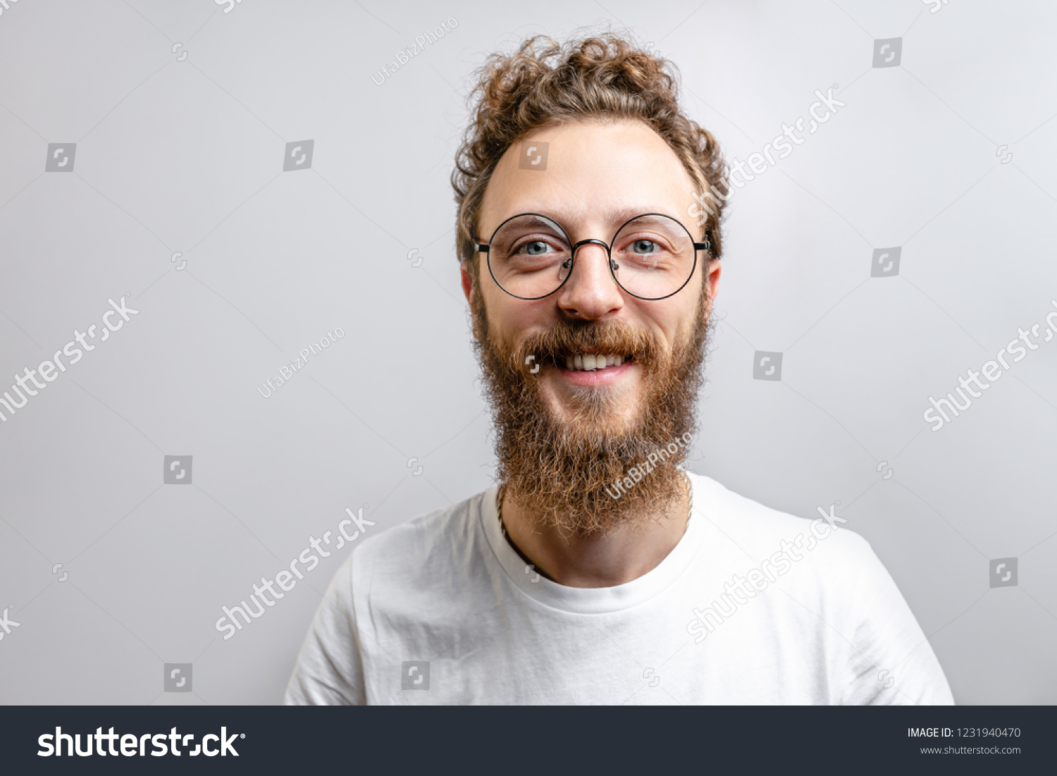 Portrait of young handsome hipster man with beard smiling laughing looking at camera over white background. #1231940470