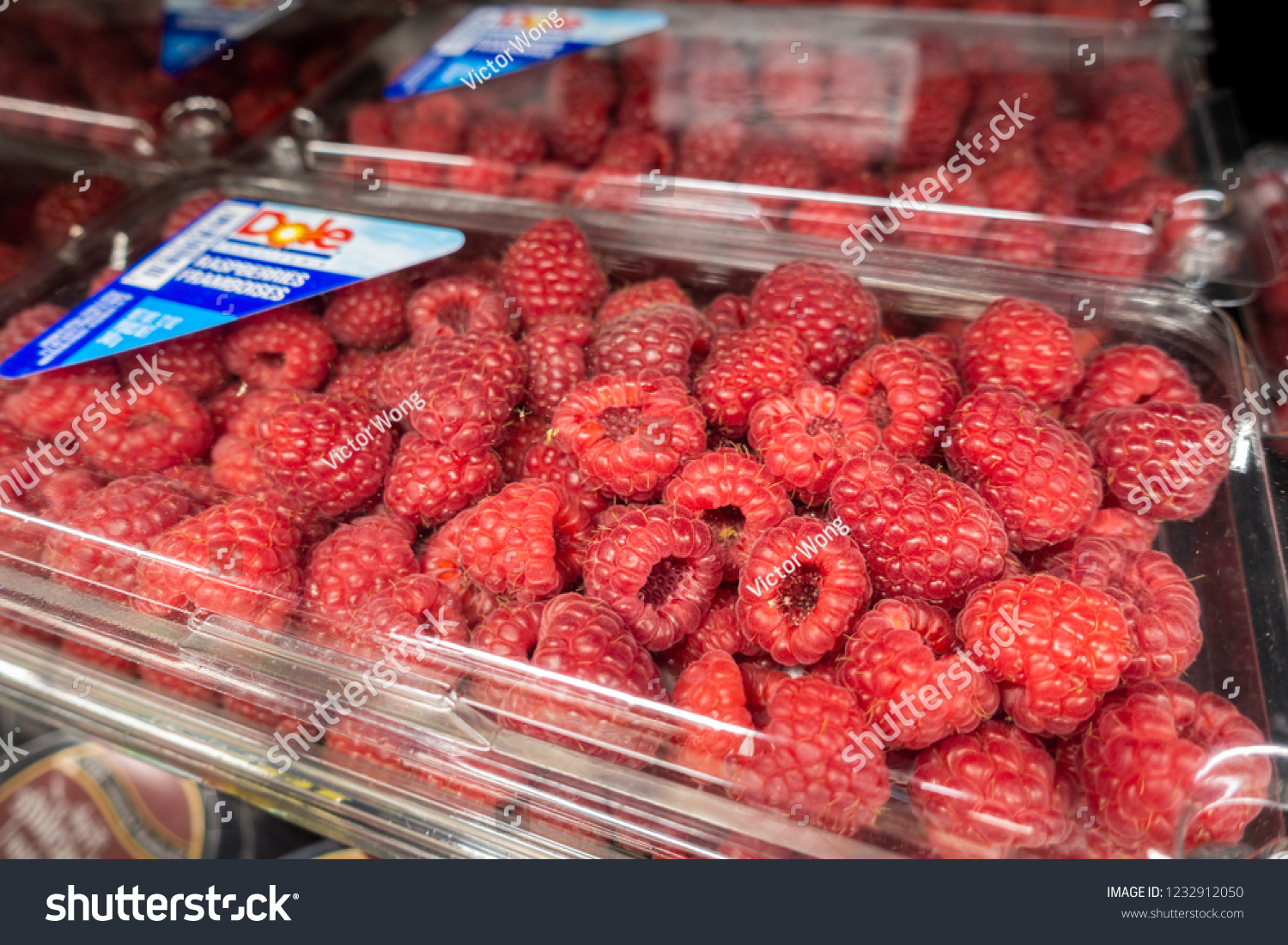 New Orleans, USA - Dec 3, 2017: Ripe raspberries packaged on display for sale at the Hong Kong Food Market shopping center. These are organized on a shelf with product details. #1232912050
