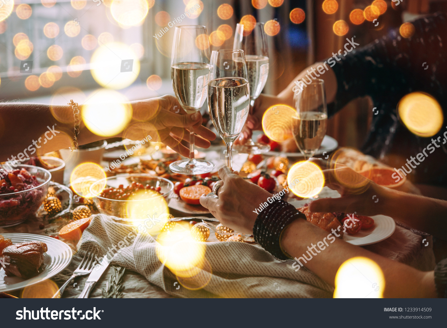 Party table with glasses of champagne. Friends celebrating Christmas or New Year eve. #1233914509