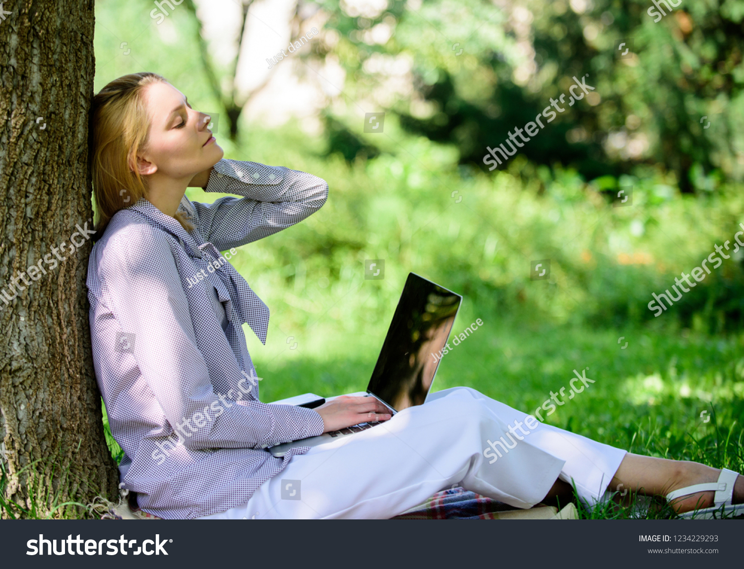 Work outdoors benefits. Woman with laptop work outdoors lean tree. Minute for relax. Education technology and internet concept. Girl work with laptop in park sit on grass. Natural environment office. #1234229293