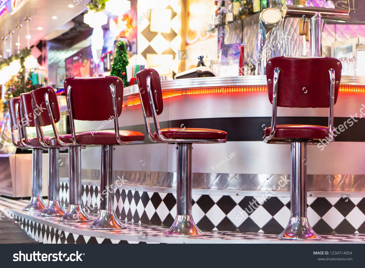 Old Fashioned Red Bar Stools In American Burger Retro Diner Restaurant. Interior Of Bar Is In Traditional American Style. Long Bar Counter. #1234714054