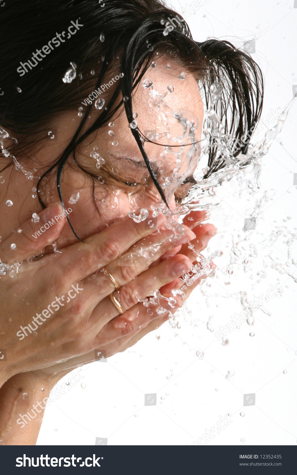 Beautiful woman washing her face (on white background) #12352435