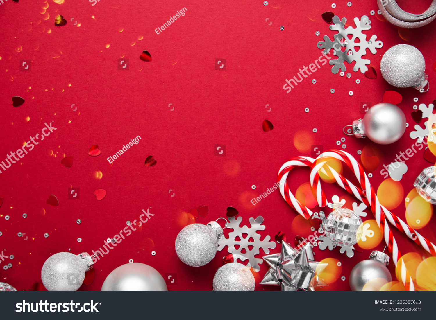 Merry Christmas and Happy Holidays greeting card, frame, banner. New Year. Noel. Christmas white and silver ornaments on red background top view. Winter holiday xmas theme. Flat lay. #1235357698