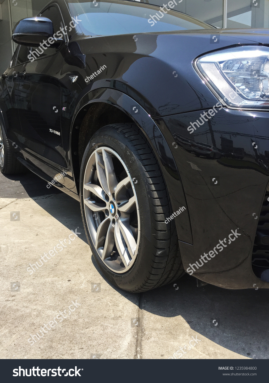 BANGKOK, THAILAND- NOVEMBER 19, 2018: Exterior front design and decoration of wheel tire and chrome rim of 'Black BMW X4 F26' sport utility SUV car from German #1235984800