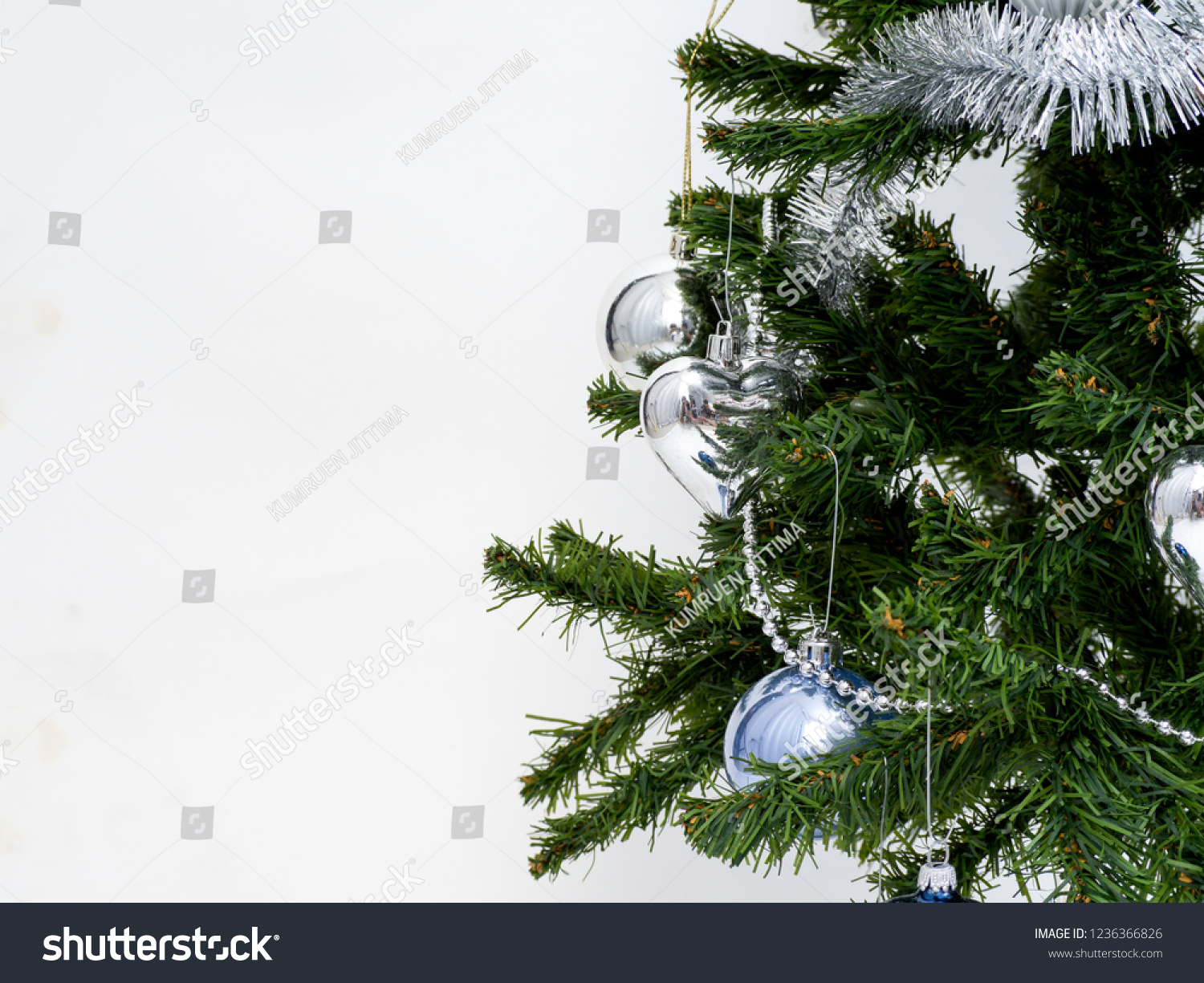 Silver Christmas decorations on a spruce branch on a white background #1236366826