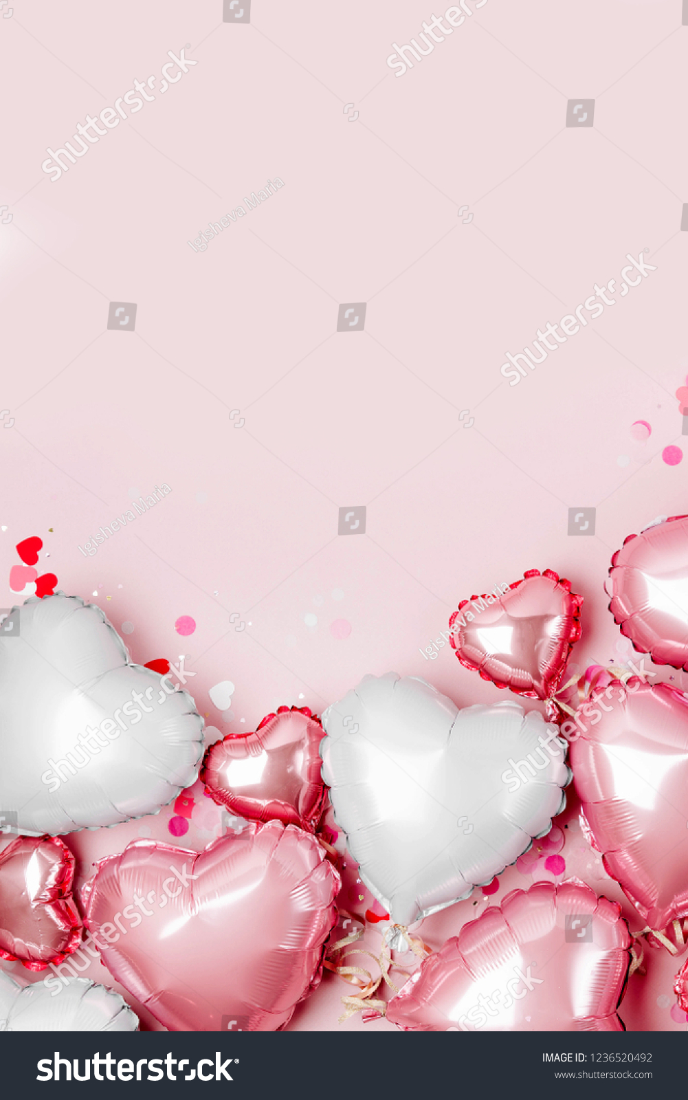Air Balloons of heart shaped foil  on pastel pink background. Love concept. Holiday celebration. Valentine's Day or wedding/bachelorette party decoration. Metallic balloon #1236520492