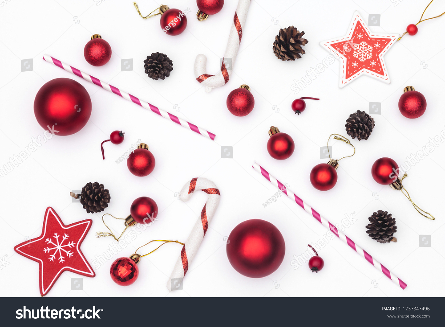 Christmas composition isolated on white. Striped straws, red glass balls and cocktail sticks. New Year flat lay, top view. #1237347496