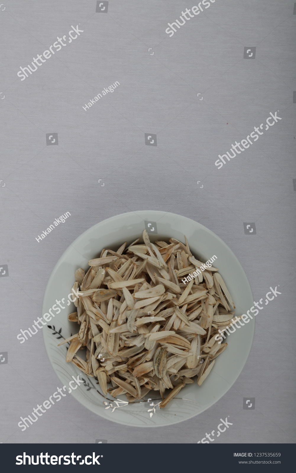 in a white container, full and empty sunflower seeds #1237535659