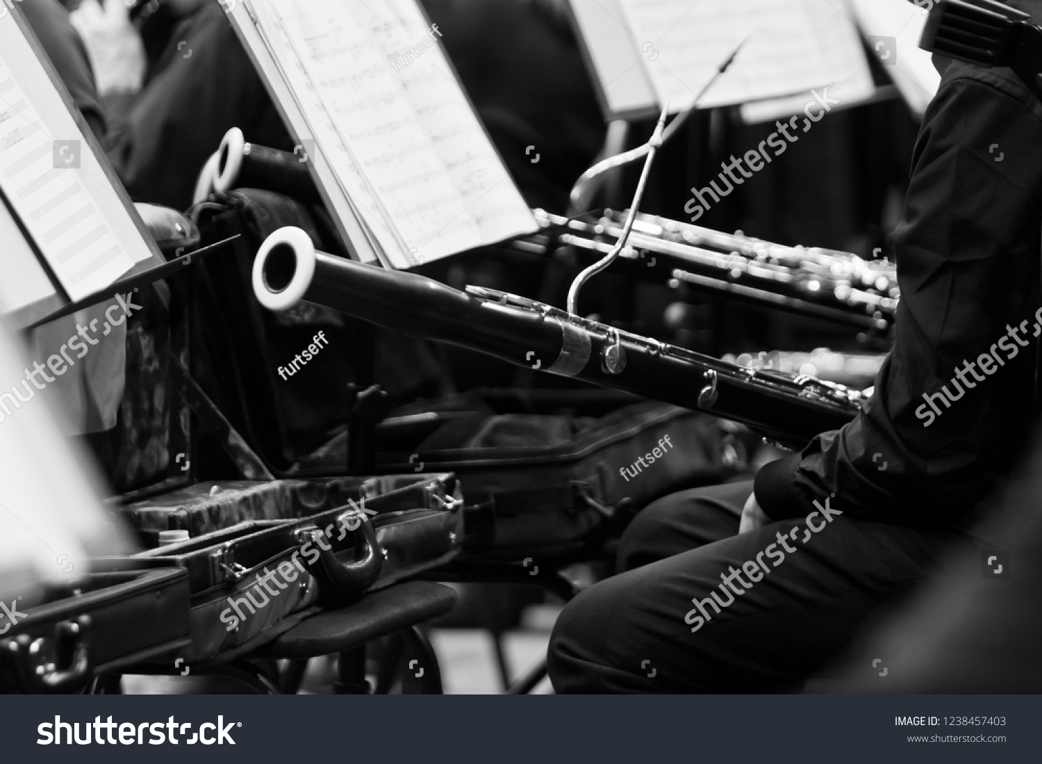 Bassoon in the hands of a musician in an orchestra in black and white closeup #1238457403