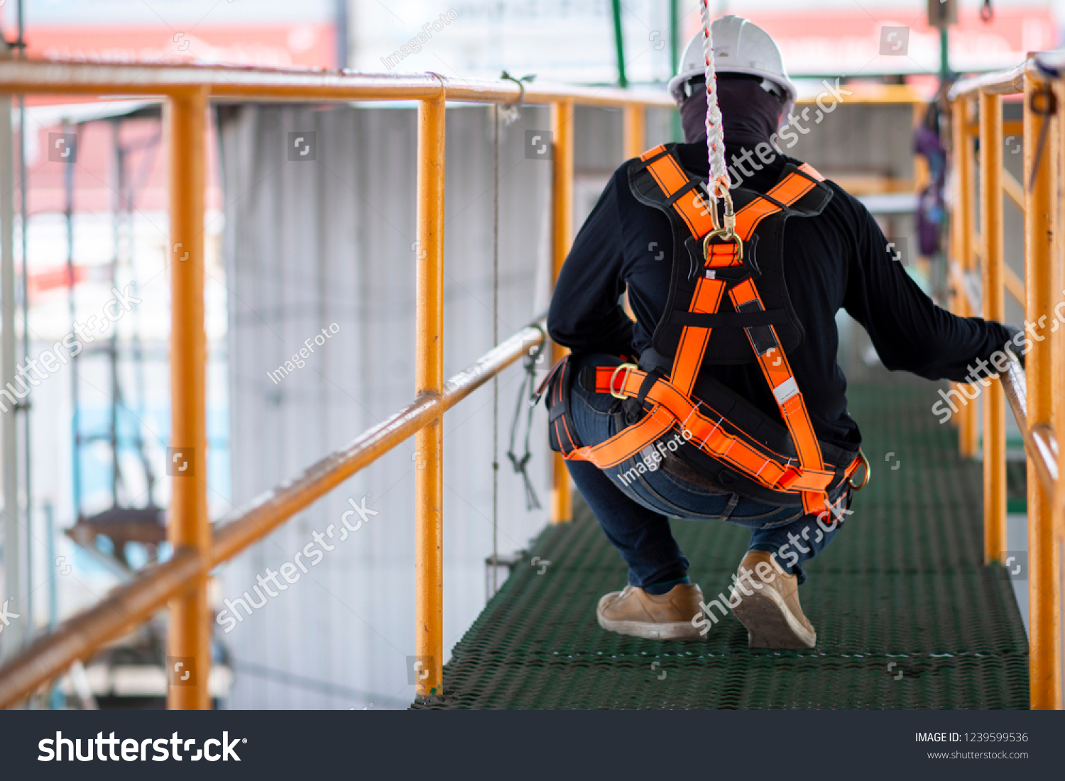 Construction worker wearing safety harness and safety line working on construction
 #1239599536