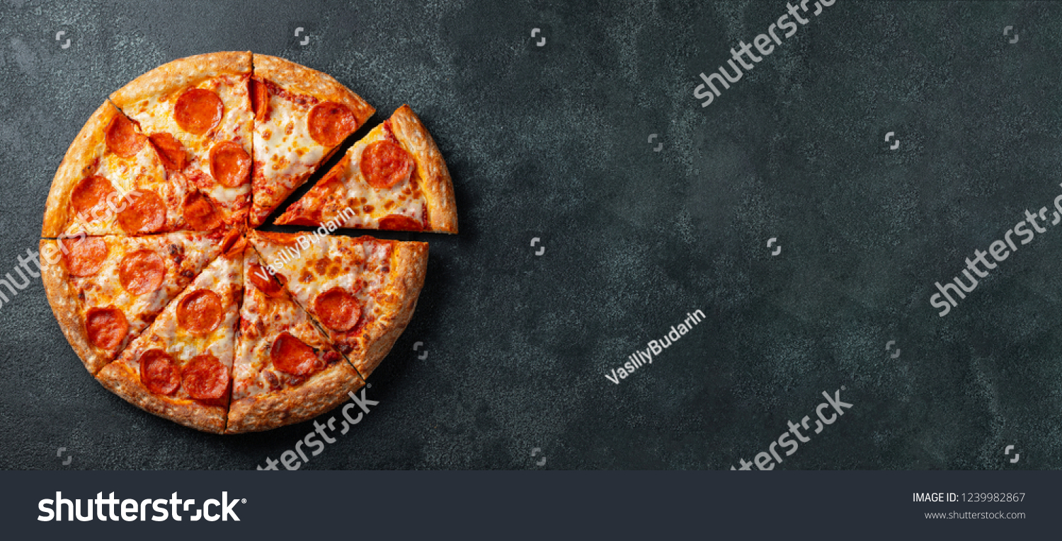 Tasty pepperoni pizza and cooking ingredients tomatoes basil on black concrete background. Top view of hot pepperoni pizza. With copy space for text. Flat lay. Banner #1239982867
