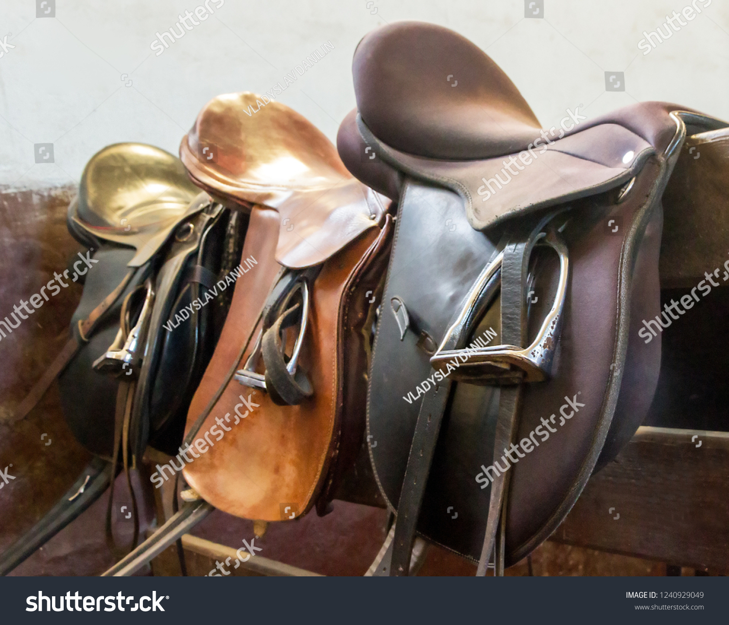 Saddle with stirrups on stallion running racing in the manege. #1240929049
