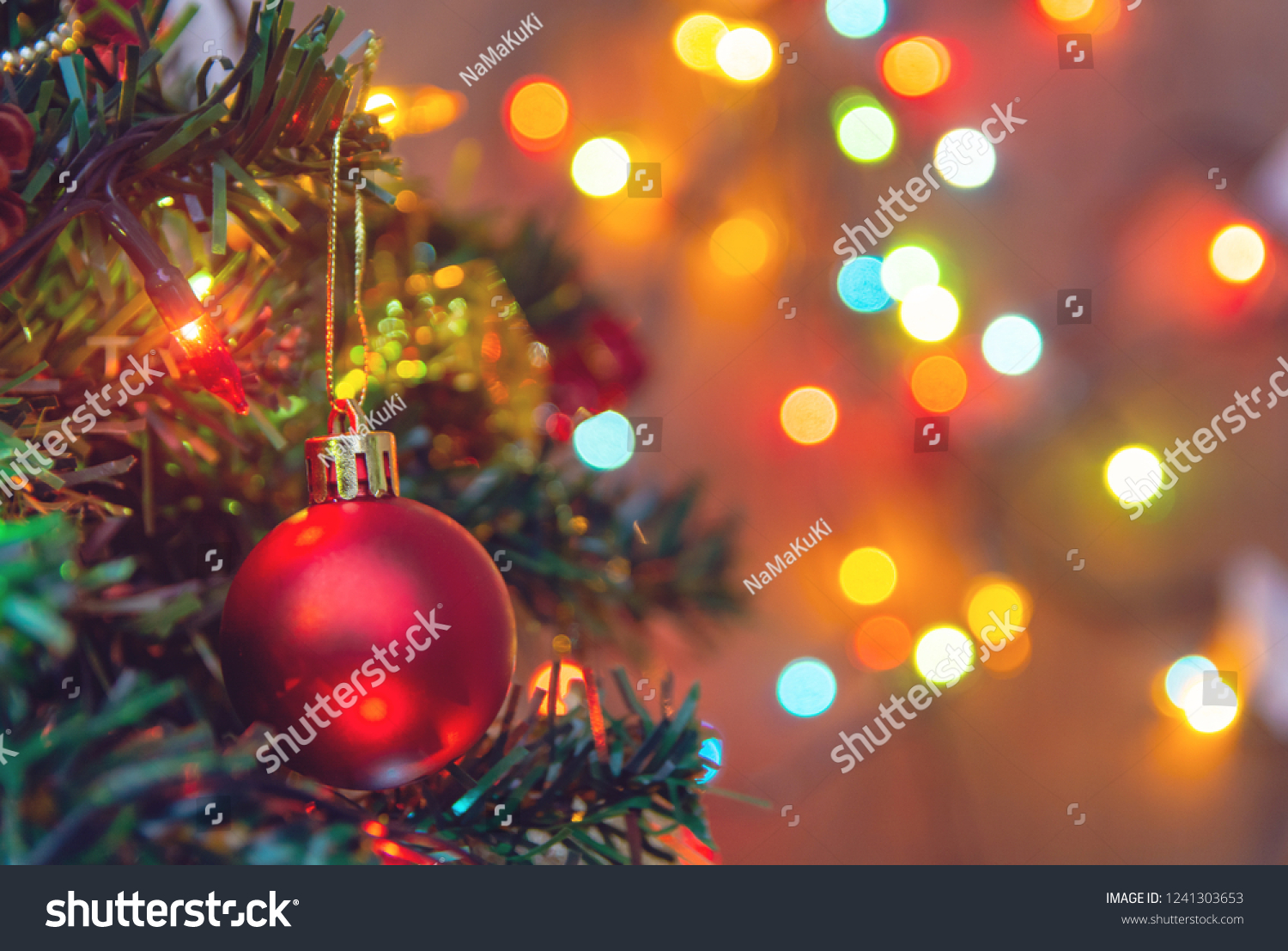 Christmas decoration. Hanging red balls on pine branches christmas tree garland and ornaments over abstract bokeh background with copy space #1241303653