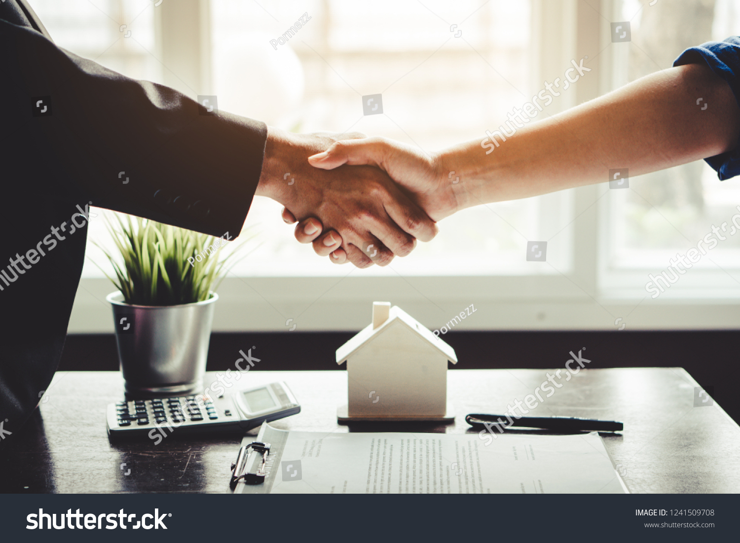 The homeowner is happy after receiving the transfer of the right to occupy the home. Agent and client shaking hands after signed document and done business deal for transfer right of property. #1241509708