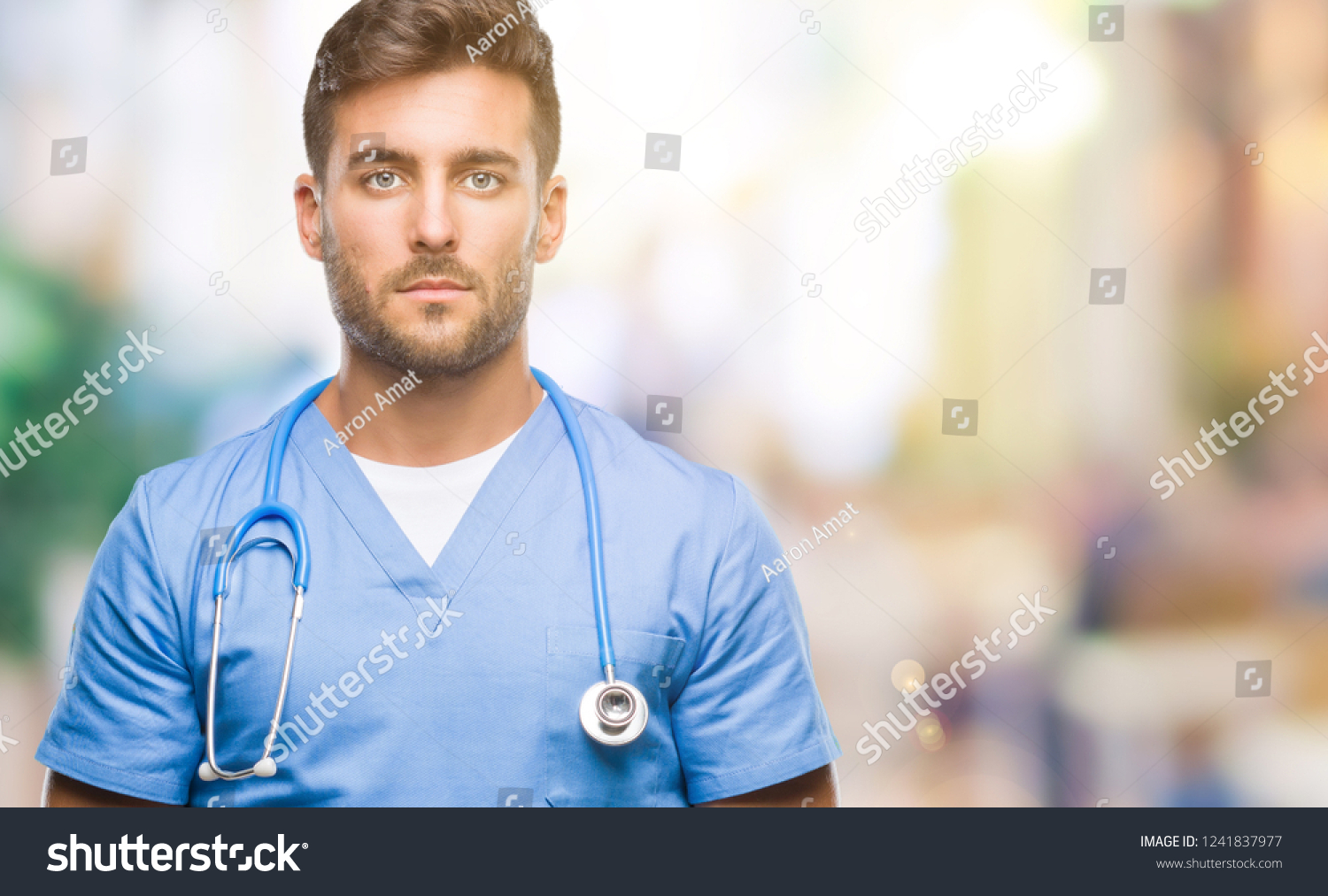 Young handsome doctor  man over isolated background with serious expression on face. Simple and natural looking at the camera. #1241837977