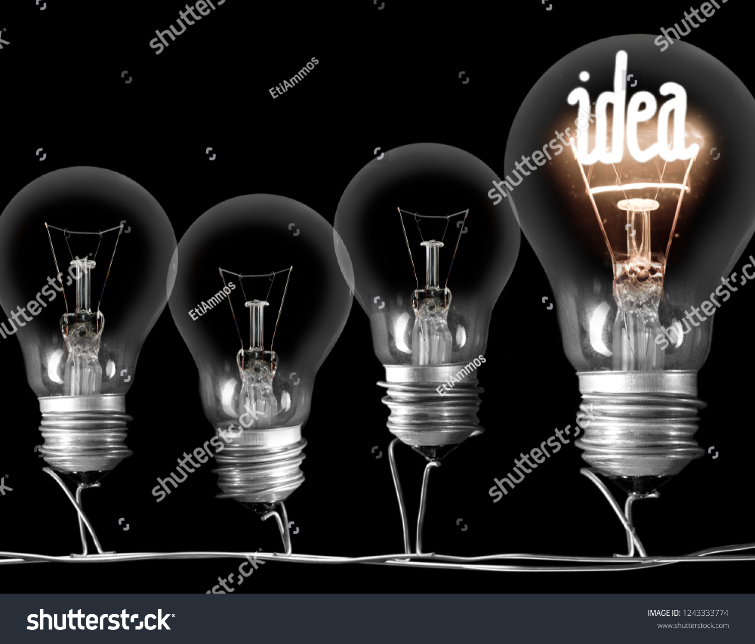 Photo of dark and shining light bulbs with fibe in IDEA shape; concept of idea, innovation, uniqueness and standing out; isolated on black background #1243333774