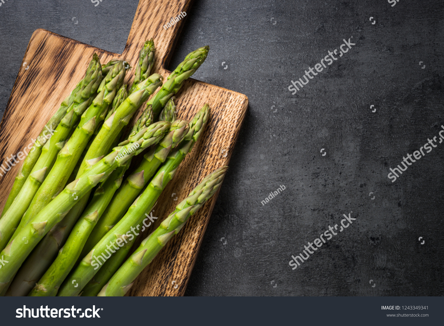 Asparagus. Fresh green asparagus on black slate background. Top view copy space. #1243349341