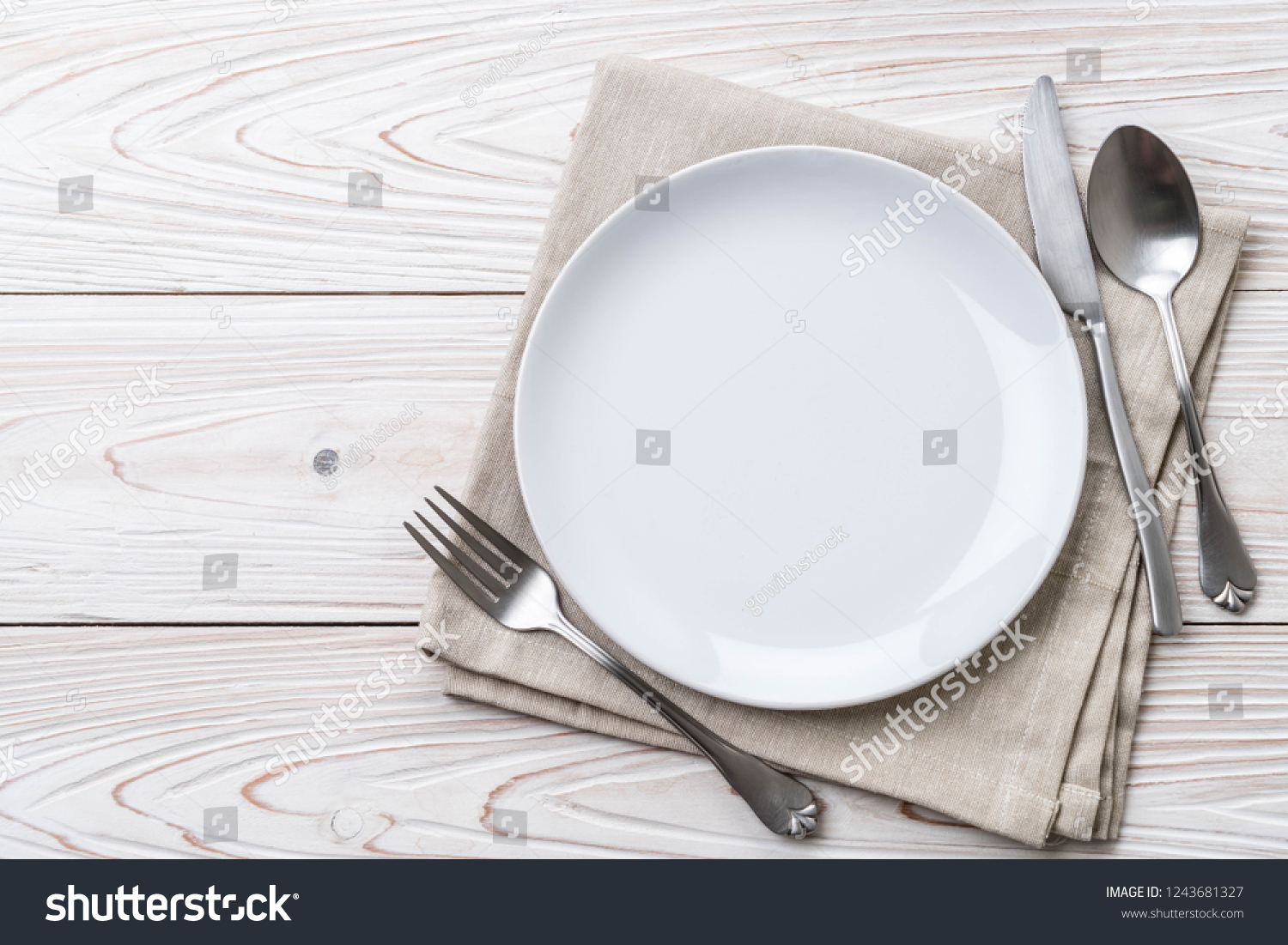 empty plate spoon fork and knife on table #1243681327