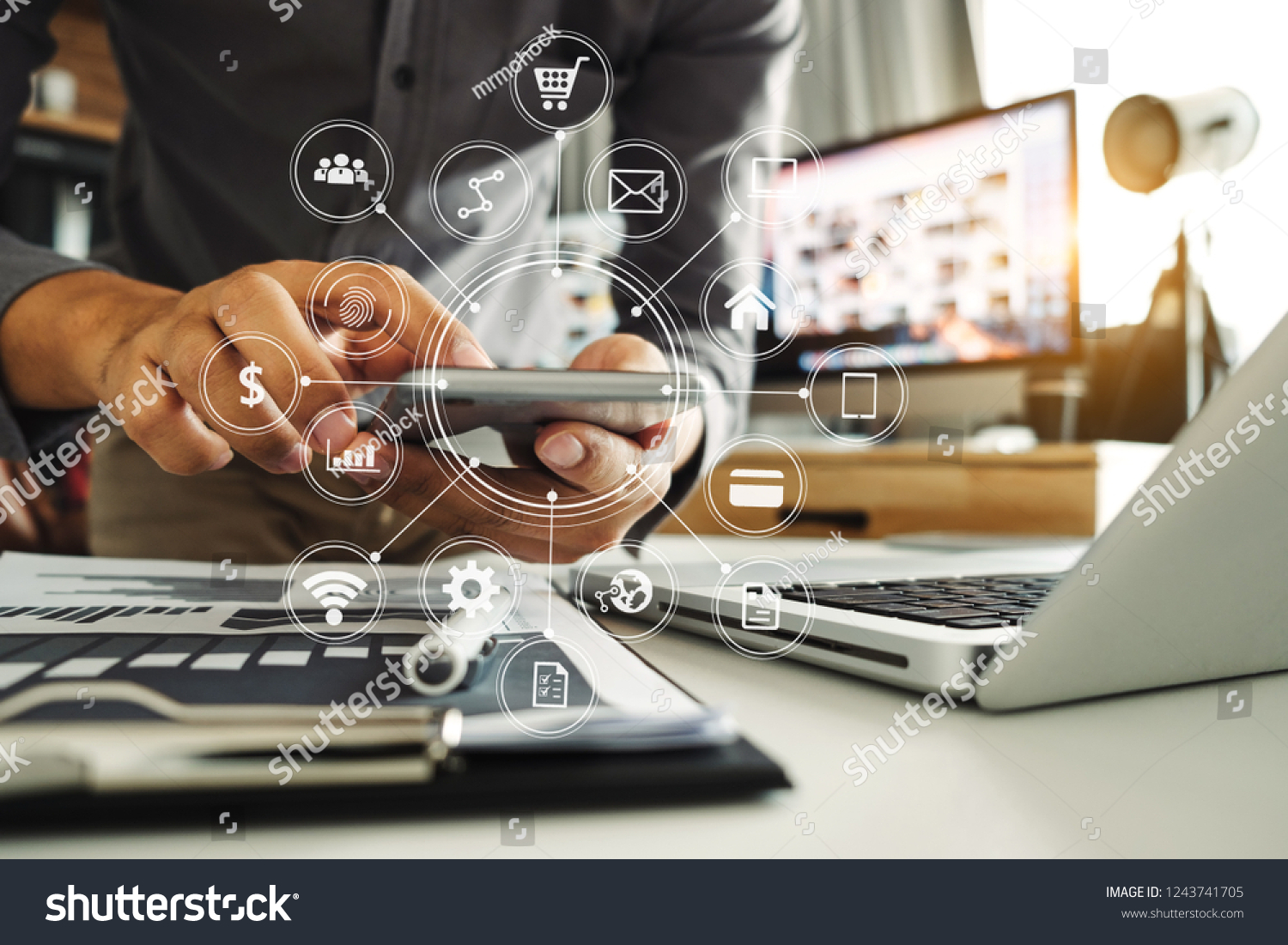 Businessman hand working digital marketing media in virtual screen with mobile phone and modern compute with VR icon diagram at office in morning light  #1243741705