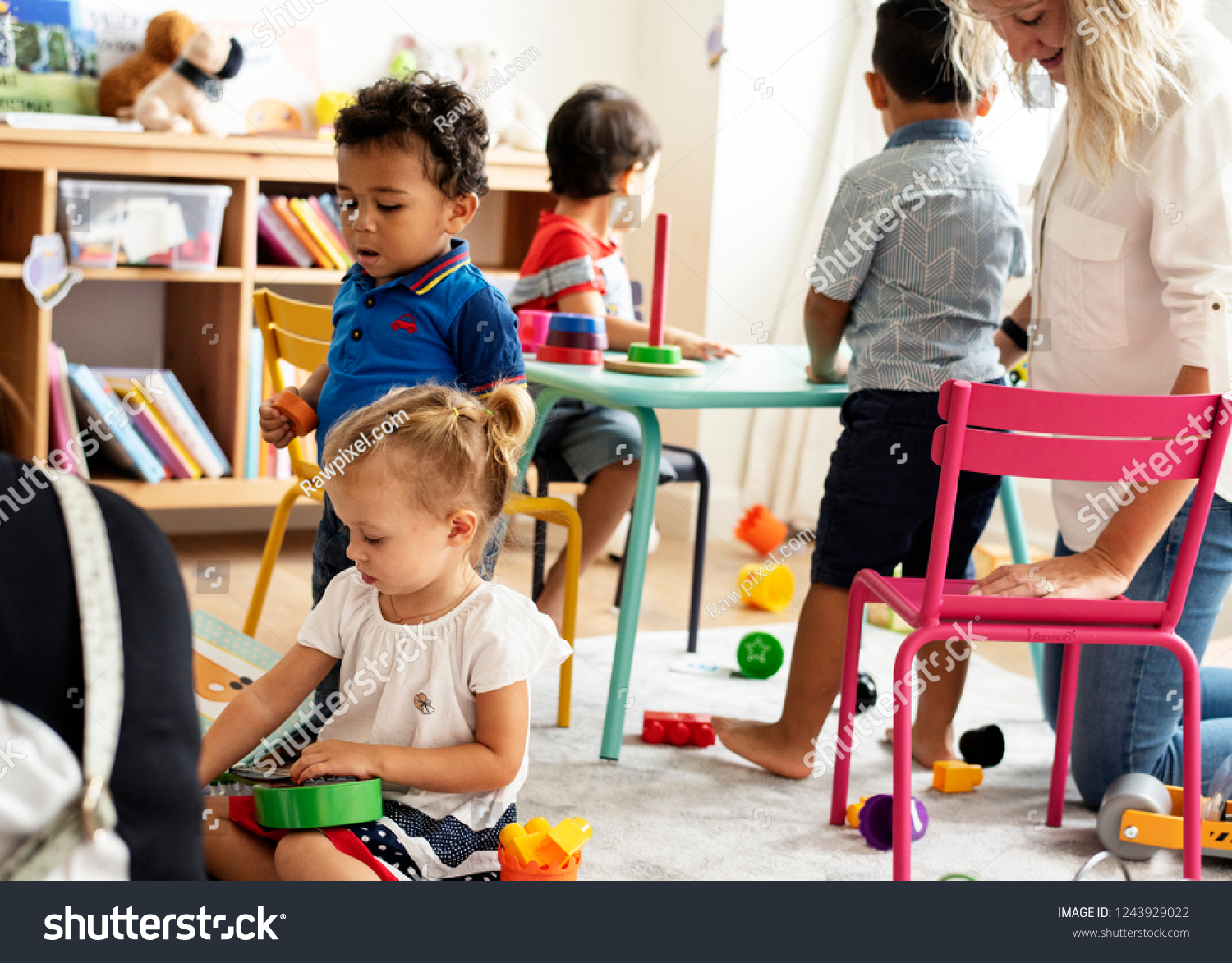Nursery children playing with teacher in the classroom #1243929022