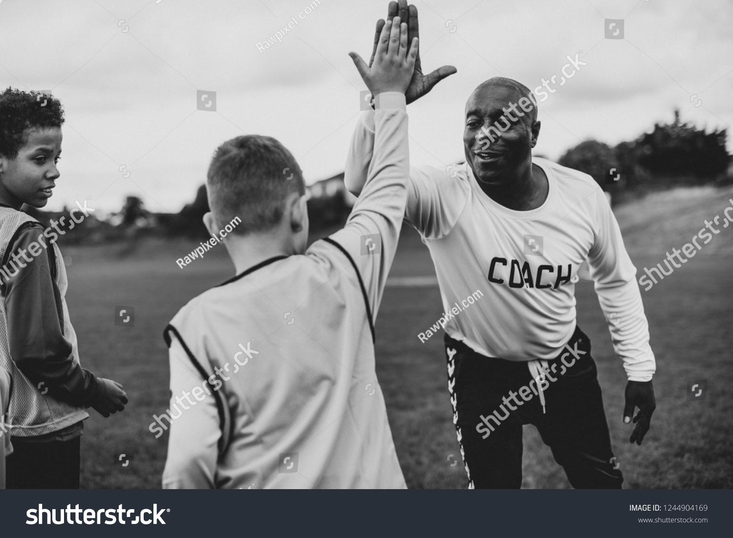 Football coach doing a high five with his student #1244904169