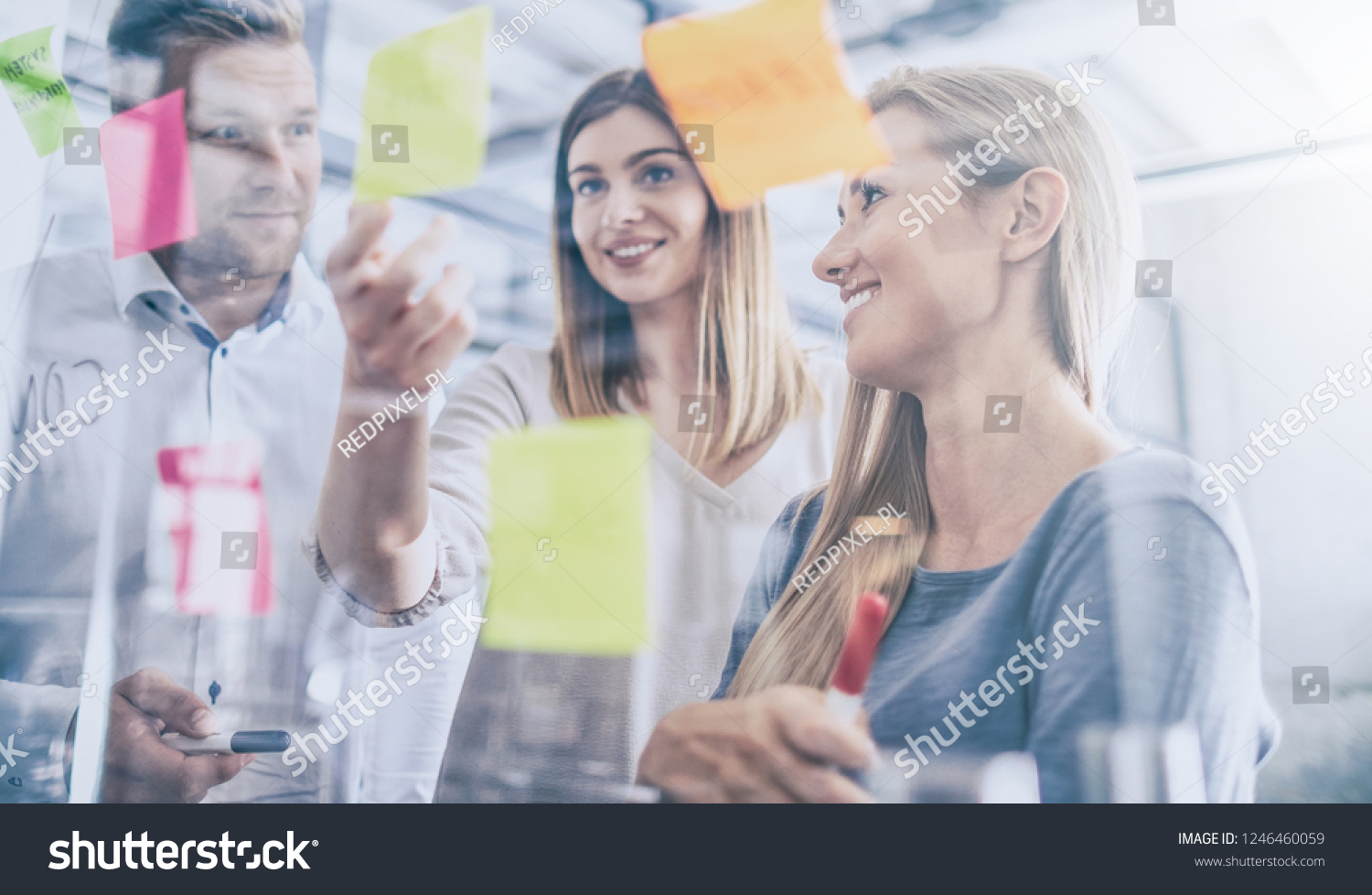 Business people meeting at office and use post it notes to share idea. Brainstorming concept. Sticky note on glass wall. #1246460059