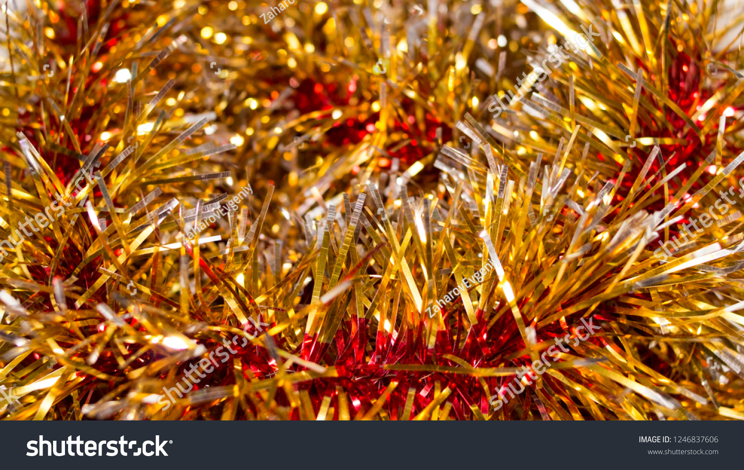 Colorful Christmas tinsel. New year's fluffy gold tinsel, tinsel, and pink tinsel. Sparkling ornament decoration concept.
 #1246837606