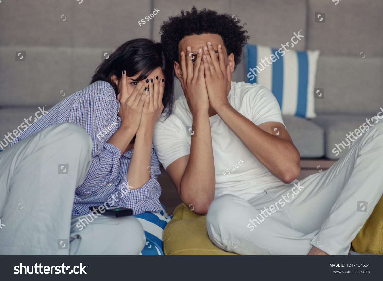 Young couple at home watching a movie with popcorn #1247434534