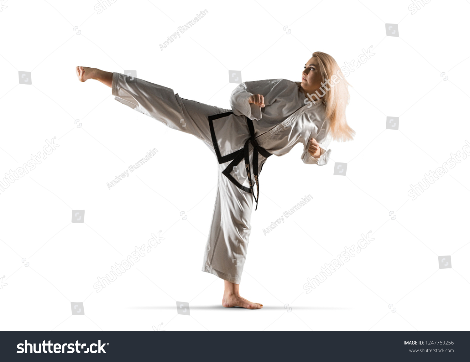 Woman in kimono practicing taekwondo. Isolated on white background #1247769256