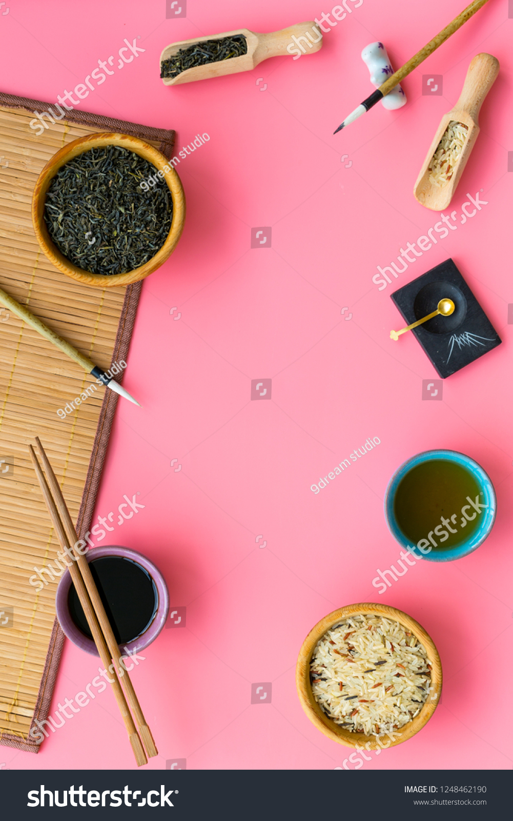 Chinese traditional symbols concept. Tea, rice, hieroglyph love, bamboo table mat, chopsticks, soy sause on pink background top view frame space for text #1248462190