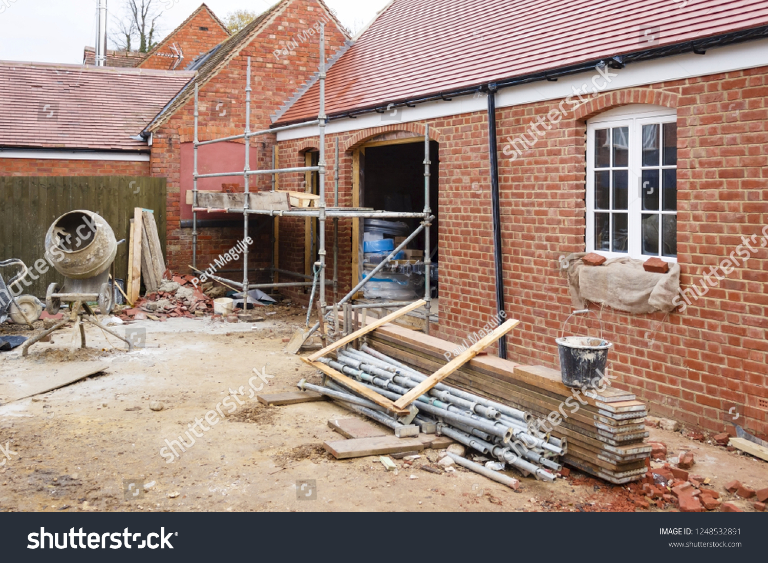 Building site in UK with brick house extension under construction #1248532891