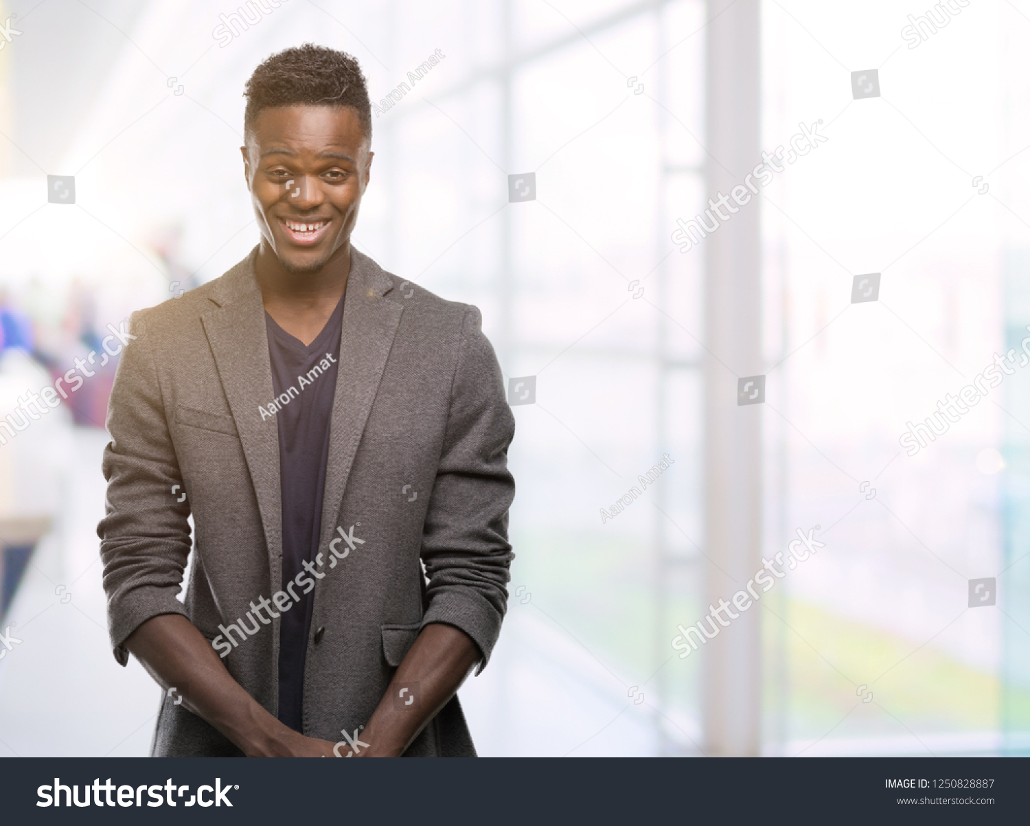 Young african american man wearing a jacket with a happy face standing and smiling with a confident smile showing teeth #1250828887