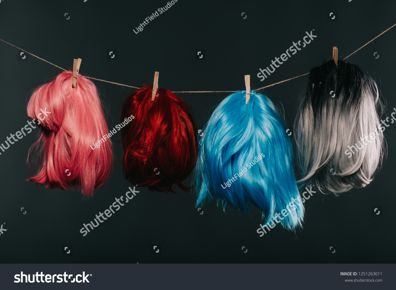 four colorful wigs hanging on rope isolated on black #1251263011