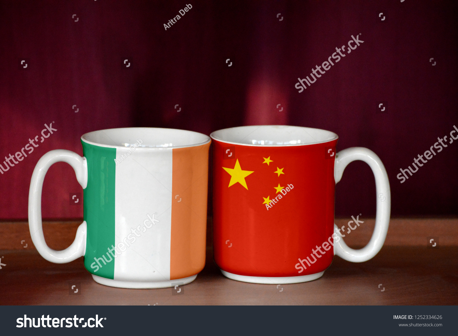 China and Ireland Ireland flag on two cups with blurry background #1252334626