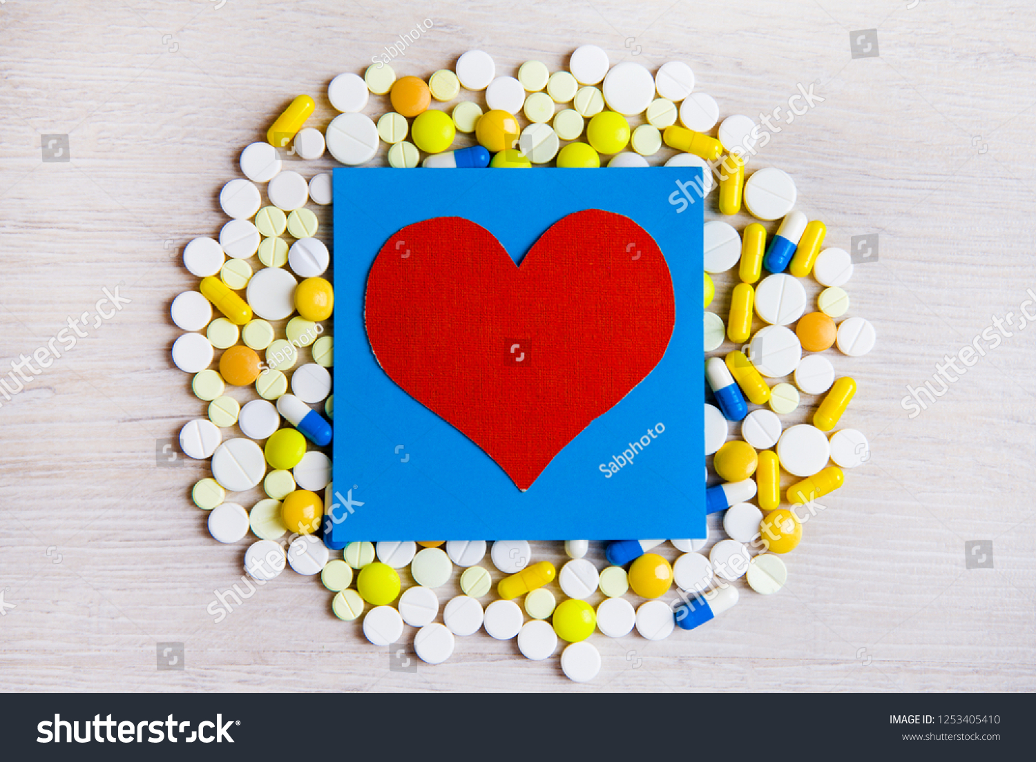 Red Heart Shape with a Pills on the Table closeup #1253405410